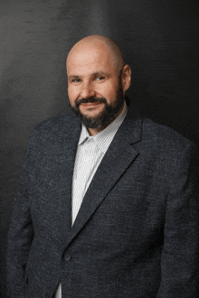 a bald man with a beard wearing a suit