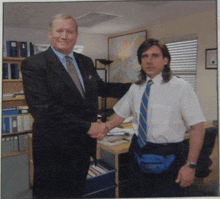 a man in a suit shakes hands with another man in a white shirt