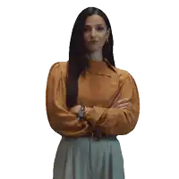 a woman standing with her arms crossed and wearing a watch