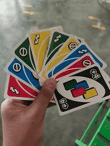 a person is holding a fan of playing cards in their hand .