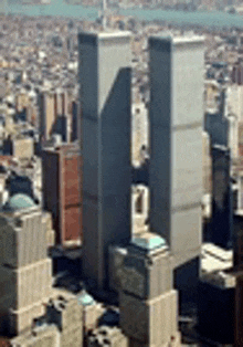 an aerial view of a city with two skyscrapers in the foreground .