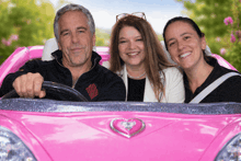 a man and two women are sitting in a pink toy car