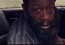 a man with a beard is sitting in the back of a car