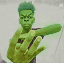 a man with a green hand is making a funny face and giving the middle finger .