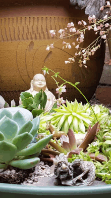 a statue of a buddha sits in a garden