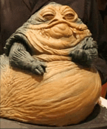 a statue of jabba the hutt from star wars is sitting on a table