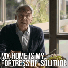 an elderly man is sitting at a table and says " my home is my fortress of solitude " in front of him