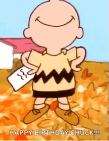 charlie brown is holding a piece of paper and smiling .
