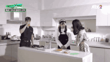 a group of people standing in a kitchen with a sign that says jtbc 2