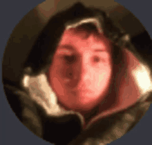 a blurry picture of a person 's face with a hood on .