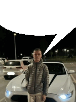 a man is standing next to a white sports car with a speech bubble above him