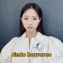 a woman is wearing a white shirt with the words rindo horrores on it