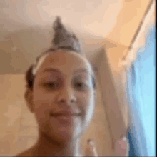 a woman wearing a crown on her head is taking a selfie in a bathroom .