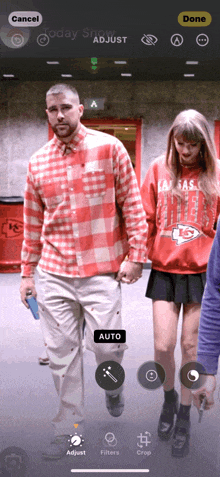 a man in a kansas city chiefs shirt is walking with a woman