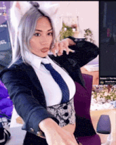 a woman in a suit and tie is standing in front of a computer