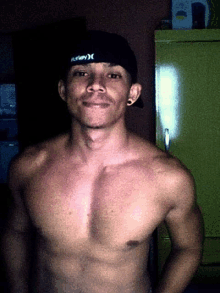 a shirtless man wears a hurley hat