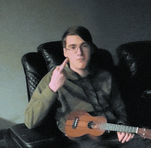 a man sitting in a chair holding a guitar giving the middle finger