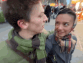 a man and a woman are looking at each other and the woman is wearing a head scarf
