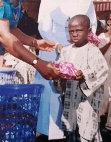 a little boy is being handed a gift by a person .