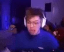 a blurry picture of a man wearing headphones and a blue sweater .