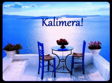 a table and chairs on a balcony overlooking the ocean with kalimera written in blue