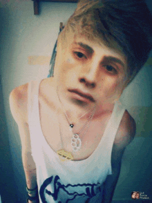 a boy wearing a tank top and a necklace with a brass knuckles pendant