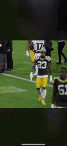 a green bay packers player wearing number 23 stands on the field