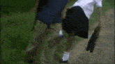 a man and a woman are walking down a road . the woman is wearing a skirt .