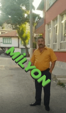 a man in a yellow shirt is standing in front of a building with milyon written on the side