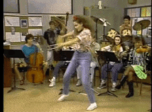 a woman playing a violin in front of a band