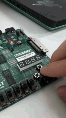 a person is pressing a button on a nexyb3 board