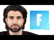 a man with long hair and a beard stands in front of a blue square with the letter f on it