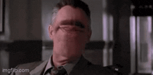 a man in a suit and tie with his mouth open .