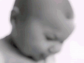 a blurry picture of a baby 's face with a pacifier in his mouth .