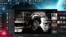 a computer screen shows a man wearing headphones in front of a group of people on a video call