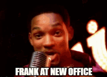 a man is singing into a microphone with the words frank at new office written on the bottom .