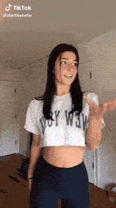 a girl wearing a white crop top that says wow on it