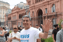 a man wearing a white shirt that says jesus esidente