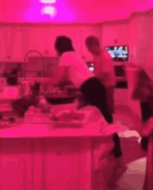 a blurred image of people cooking in a kitchen with pink lights