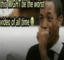 a man is covering his mouth with his hand in front of a meme that says this might be the worst video of all time .
