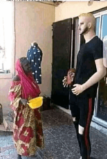 a man is standing next to a woman holding a yellow bowl .