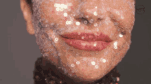 a close up of a woman 's face covered in sequins with a watermark that says lyng