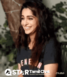 a woman is smiling in front of a sign that says " star tamil chat "