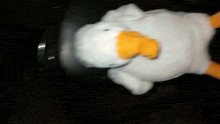 a stuffed duck with a yellow beak is laying down