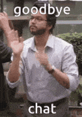 a man with a beard is clapping his hands and saying goodbye and chat .