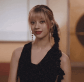 a woman wearing a braided ponytail and earrings is looking at the camera