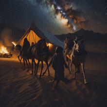 a group of people riding camels in a desert at night