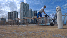 a man is jumping over a fence with a stroller