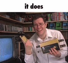 a man holding a device in front of a television with the words " it does " on the bottom