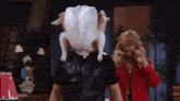 a man wearing a turkey mask is standing next to a woman .